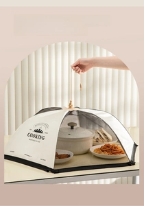 Détail d'une cloche alimentaire pliable en maille protégeant les plats sur la table