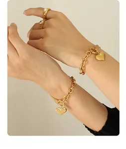 Close-up of 18K gold plated Cuban chain bracelet with heart charm and pearl ring