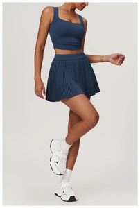 Detail view of navy blue square neck sports tank top with side shirring and pleated skirt
