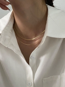 Minimalist double layered gold snake chain necklace for women on a white shirt