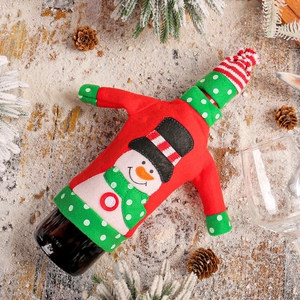 Christmas snowman wine bottle cover decoration on rustic wood background with snow