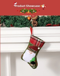 Detail of green Christmas stocking with Santa Claus applique hanging on a fireplace