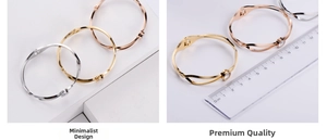 Detailed view of twisted titanium steel bangles in gold and silver with single zircon accent