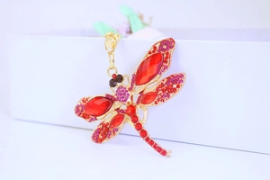 Macro shot of dragonfly keychain with red crystals and shimmering pink rhinestones