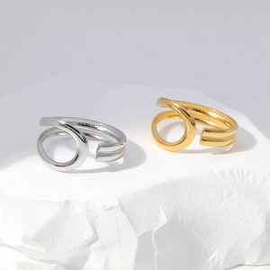 Detailed view of spiral open rings in gold and silver finish on stone display