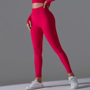 Detail view of red high-waisted seamless yoga leggings and long sleeve crop top with thumbholes