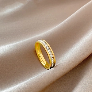 Anello in titanio dorato lucido con una fila completa di zirconi cubici quadrati scintillanti