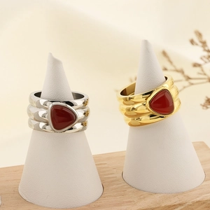 Irregular gold and silver rings with red turquoise inlay displayed on white ring cones