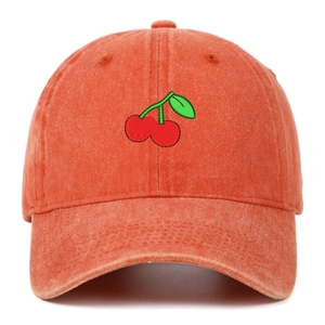 Close-up of cherry embroidery and vintage washed texture on orange cotton baseball cap