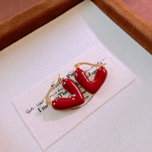 Detail view of vintage red heart enamel hoop earrings with polished gold finish