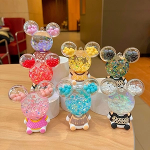 Cartoon acrylic liquid bottle keychain with mini figurines on a wooden desktop display