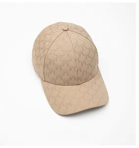 Detail of khaki baseball cap featuring textured embossed geometric pattern and hard brim