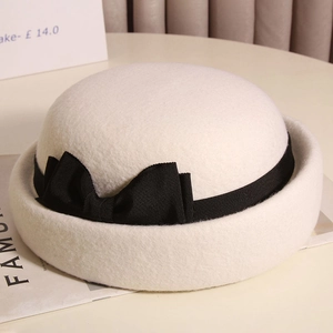 Elegante cappello cloche in lana bianca con fiocco nero e tesa arrotolata retrò