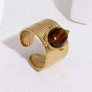 Detail of gold wide band ring with wavy texture and large oval tiger eye stone inlay