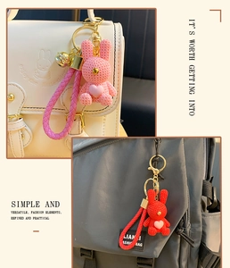 Detail of pink resin bunny keychain with textured weave pattern and heart on a beige bag