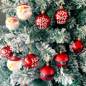 Close-up of Christmas ornaments with Santa filling and HO HO HO print on snowy branches