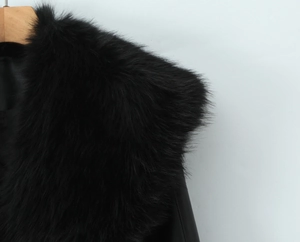 Détail du col en fausse fourrure noire sur une veste d'hiver chic et cintrée en cuir