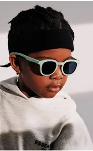 Detail view of mint green matte sunglasses for kids featuring classic silver rivets