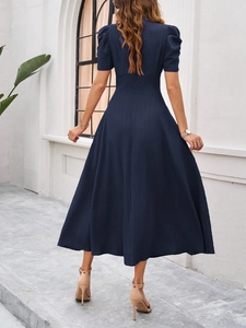 Back view of elegant navy blue midi dress with puff sleeves and pleated skirt details