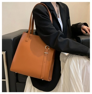 Brown soft leather tote bag for women shown in a professional business commute setting
