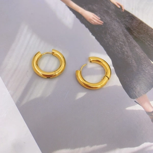 French style 18K gold chunky hoop earrings with high polish finish on fashion magazine