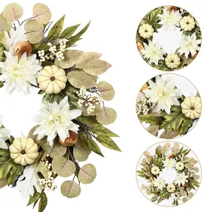 Autumn wreath with white dahlias, cream pumpkins and eucalyptus leaves on white backdrop