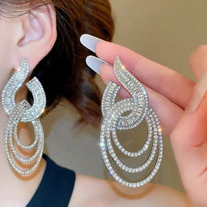 Macro shot of silver dangling earrings with sparkling crystals for elegant evening wear