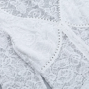 Gros plan sur tissu en dentelle blanche avec rivets argentés et coutures en mesh