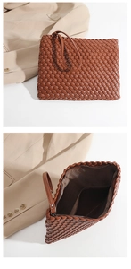 Detail of a brown woven clutch bag with top handle and interior zipper compartment