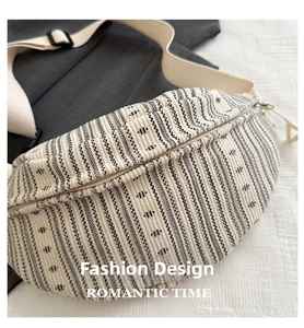 Detail of striped crossbody bag with textured fabric, adjustable strap, and metal zipper