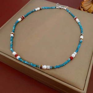 Ethnic style necklace with turquoise beads, white pearls, and tiger eye stone accents