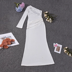 Détail d'une robe longue blanche à une épaule avec des plis froncés élégants sur le côté