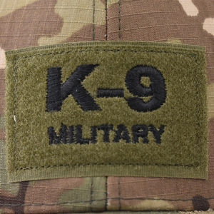 Army green K-9 MILITARY embroidered tactical patch on a woodland camouflage background
