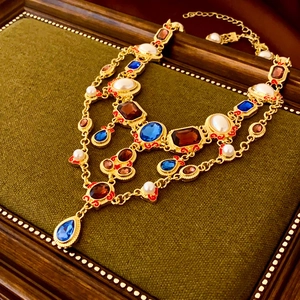 Detailed close-up of Baroque style vintage necklace with blue gems and white pearls