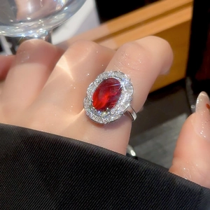Close-up of a luxury silver ring with an oval ruby and double halo diamond setting