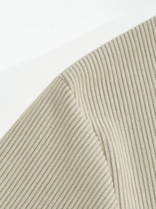 Close-up of beige corduroy ribbed texture and seam details on a men long sleeve shirt