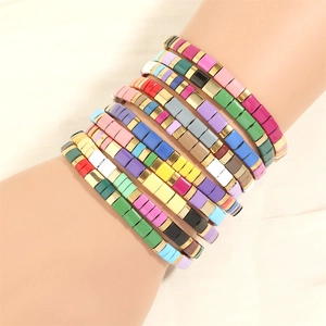 Close-up of stacked macaron color Tila bead bracelets with colorful enamel tiles and spacers