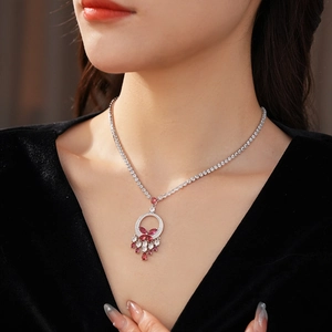 Close-up of a silver butterfly necklace with pink and white zircon gemstones on model