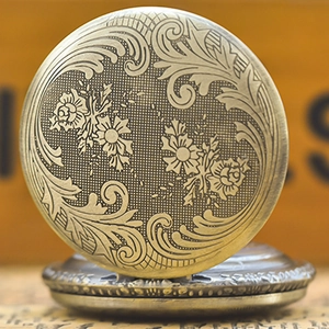Macro detail of vintage bronze pocket watch featuring intricate floral relief and textures