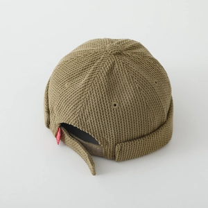 Détail du bonnet docker en maille gaufrée avec sangle réglable et étiquette rouge