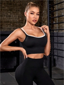 Detail of breathable nylon yoga set showing white contrast trim on black sports bra
