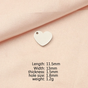 Detailed view of silver heart pendant with size measurements on peach fabric