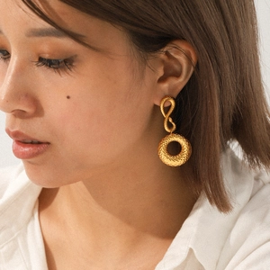 Gros plan sur des boucles d'oreilles doubles anneaux texturés en acier doré 18 carats