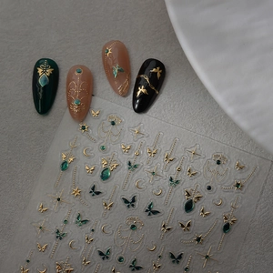 Detail of gold butterfly nail stickers with star and moon patterns on various base colors