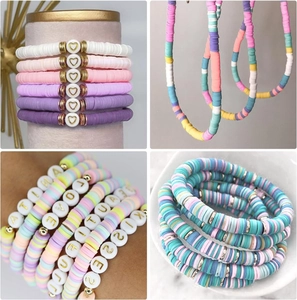 Détail de bracelets en perles heishi colorées avec breloques dorées en forme de cœur