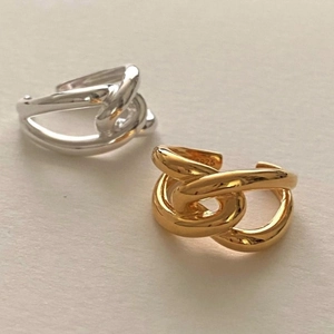 Macro shot of S925 silver and gold-plated chain link rings in a twisted cross design