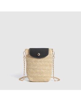 Close-up of woven straw texture with black PU leather flap and gold metal chain strap