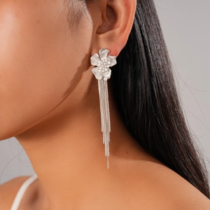 Detail of silver flower tassel earrings with zircons and pearls on model