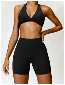 Detail of black halter twist sports bra and high waisted yoga shorts set for fitness