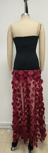 Detail of burgundy tulle skirt with 3D floral accents and black tube top evening dress